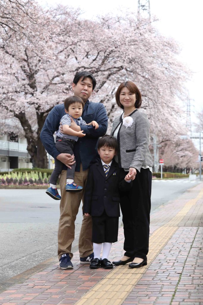 桜を背景に入学記念家族写真