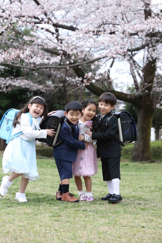 桜を背景に入学記念家族写真