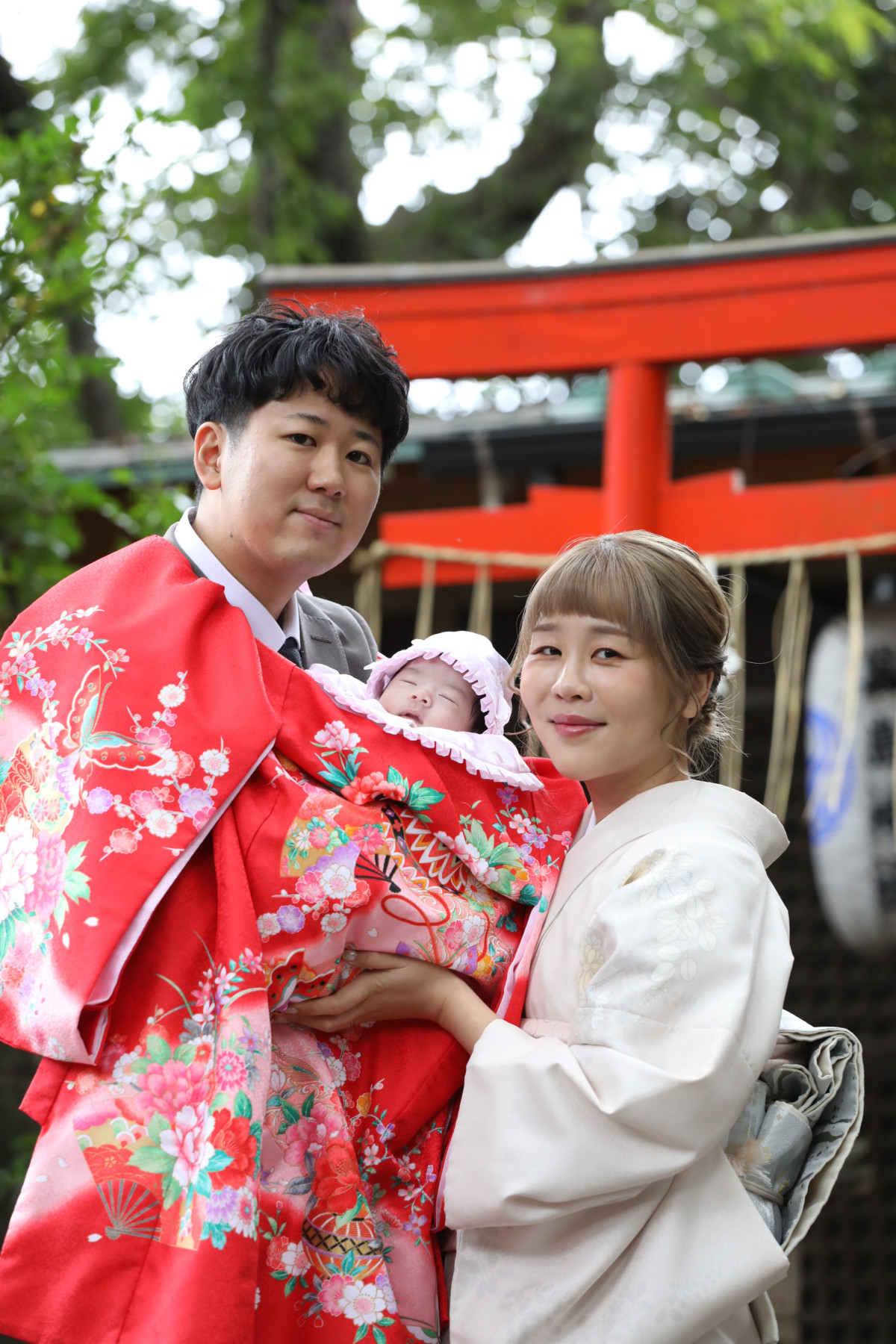 武蔵野八幡宮の鳥居で撮影した赤ちゃんと家族の半身写真