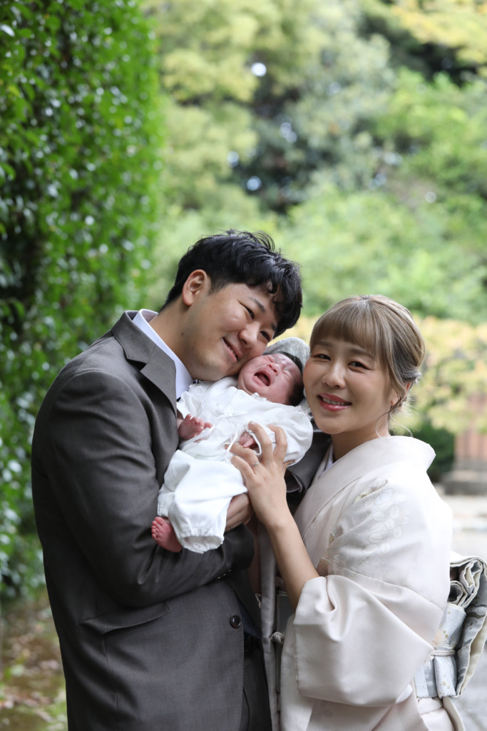 掛け着を外して家族三人がほっぺを寄せた武蔵野八幡宮のお宮参り写真
