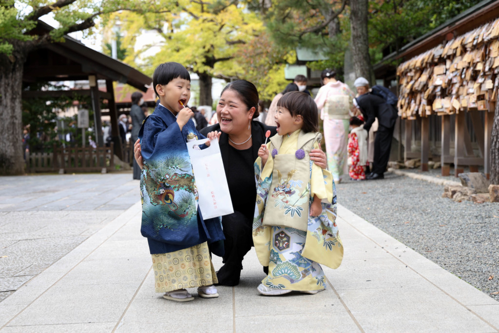 船橋大神宮で叔母と兄弟が飴をやり取りする七五三写真
