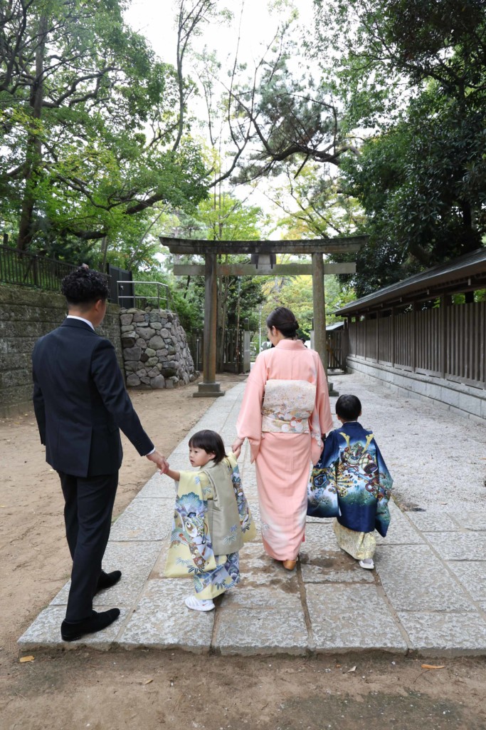 船橋大神宮を歩く家族4人の後ろ姿と振り返る弟の七五三写真
