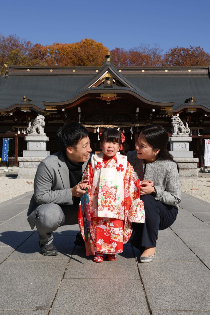 立川諏訪神社の本殿と青空を背景にした3歳のお嬢さんの七五三ポートレート