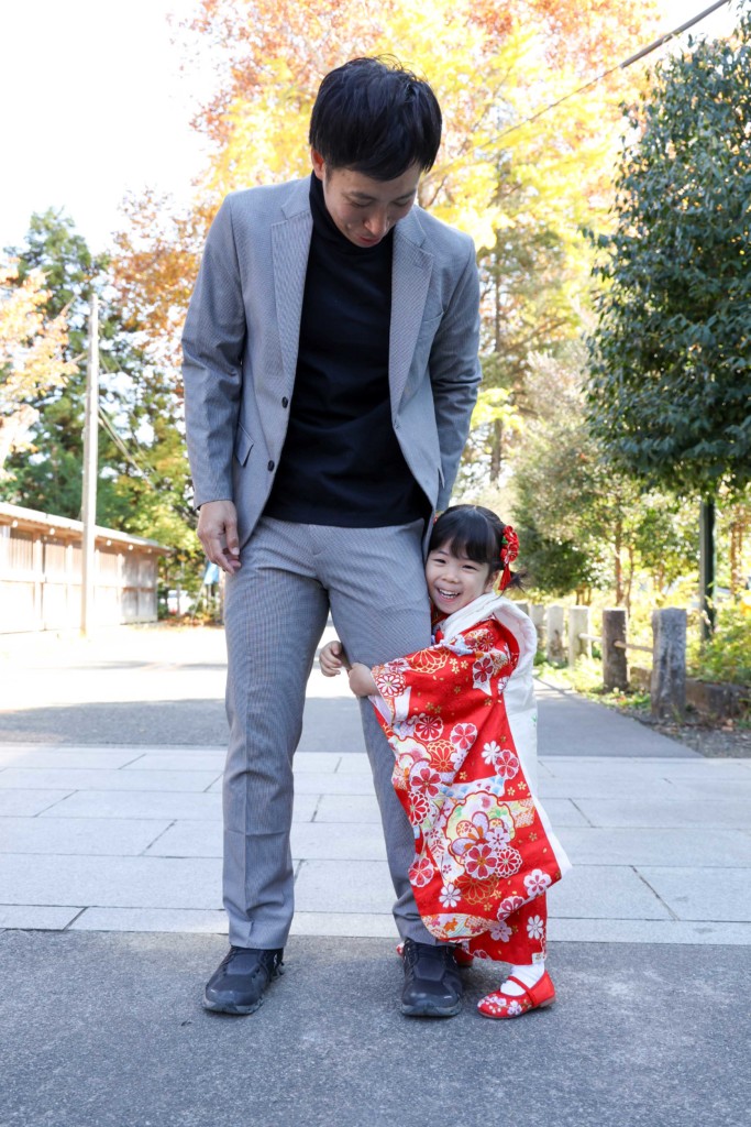 パパにしがみつくはしゃぐ3歳のお嬢さんの七五三写真