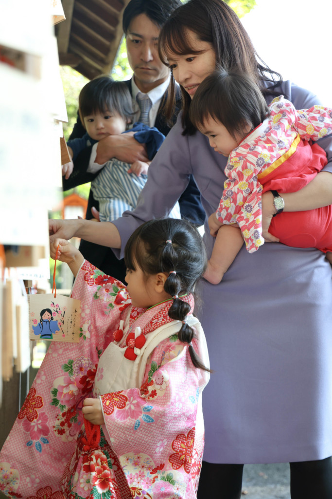 谷保天満宮で家族全員が絵馬を掛けている横顔。全員の顔が見える構図で撮影。